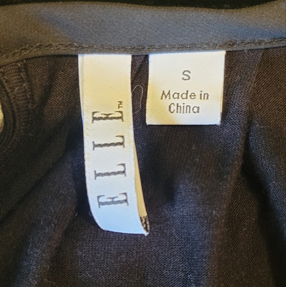 Elle size small black with white stripes on the front and a button in back - Picture 3 of 3